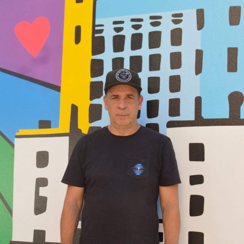 Mural colorido representando monumentos brasileiros com pedestres caminhando na Rua Augusta, em São Paulo.